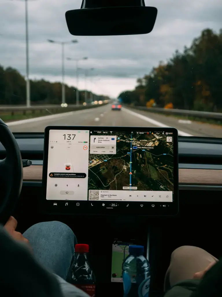 A driver on the highway with navigation on the car's dashboard screen