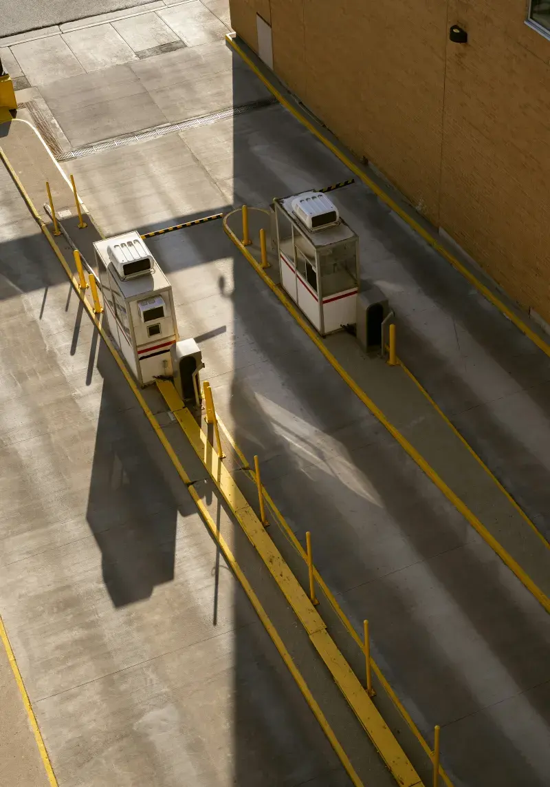 Two parking garage entry lanes with booths and gate arms, seen from above