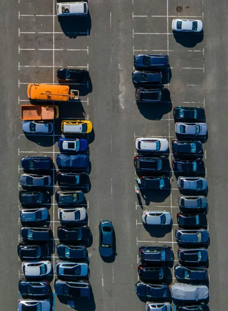 A surface parking lot with a QR payment sign at the entrance
